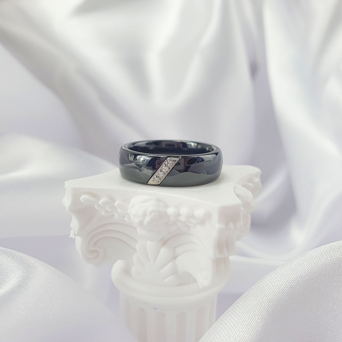 Black ceramic ring with a slanted zirconia band on an antique column