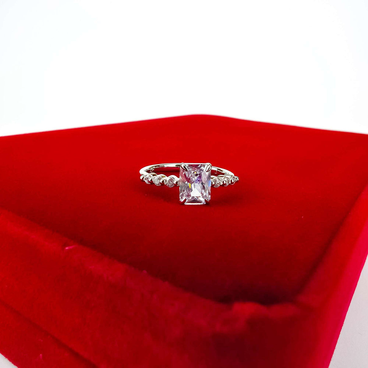 Silver-tone rectangular crystal ring on a red velvet gift box