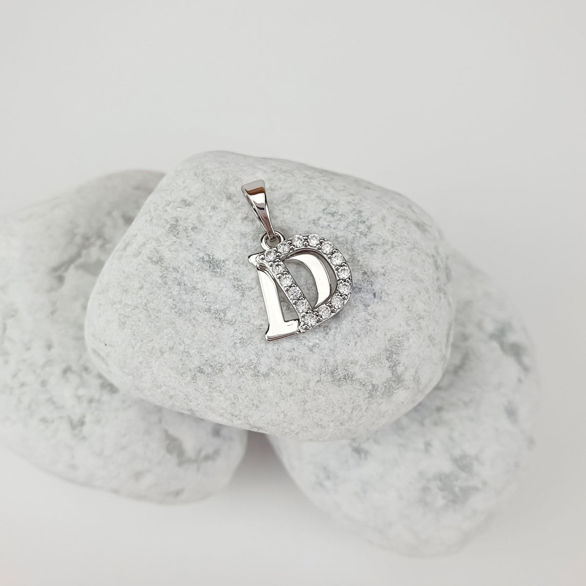 Initial D pendant with cubic zirconia on light stones, side close-up