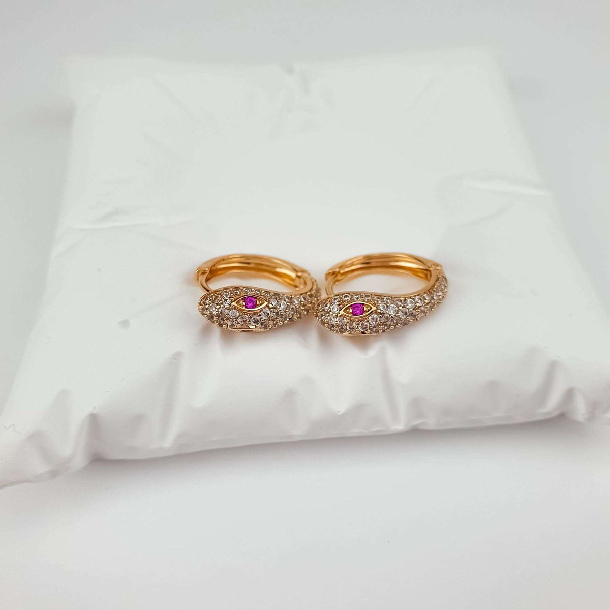 Pair of gold-plated snake earrings with white cubic zirconia and bright pink eyes