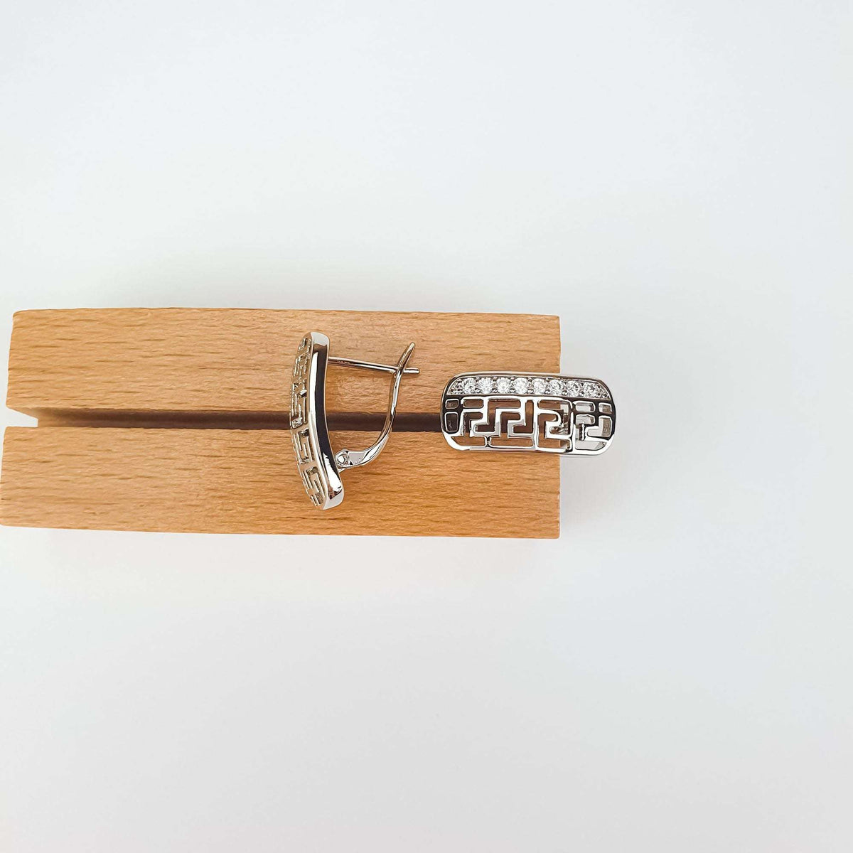 Pair of earrings on a wooden stand, leverback clasp and zirconia visible