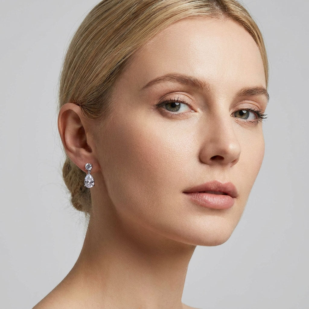 Model wearing platinum-plated teardrop earrings, showing their size and drop