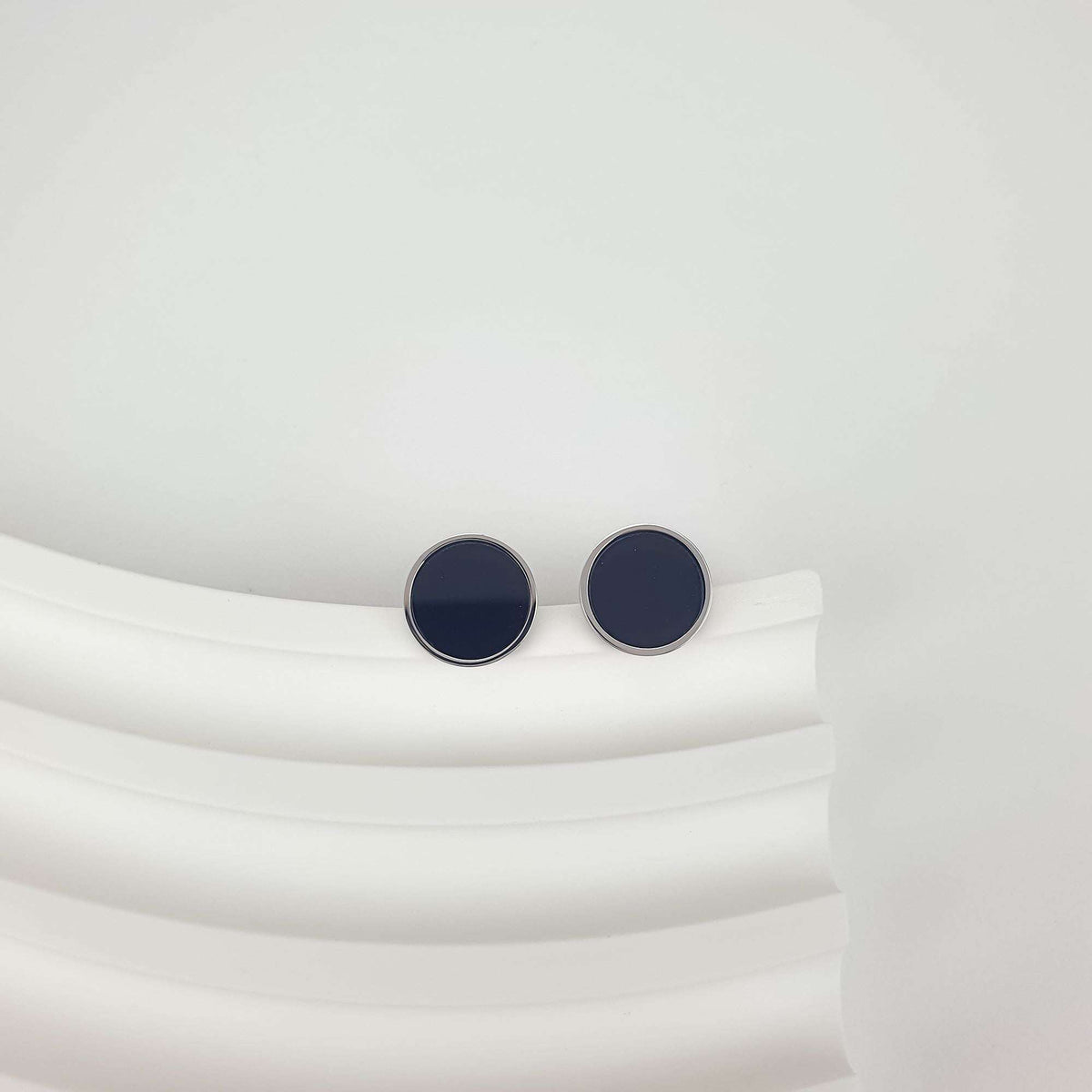 Minimalist studs with a black enamel circle and shiny rhodium rim
