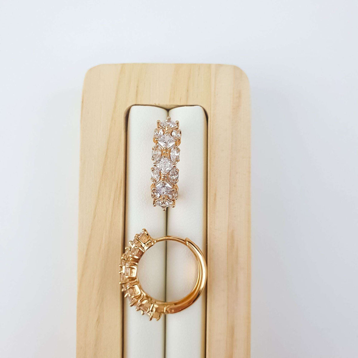 White | Earrings on a wooden stand with clear stones and hinged closure visible
