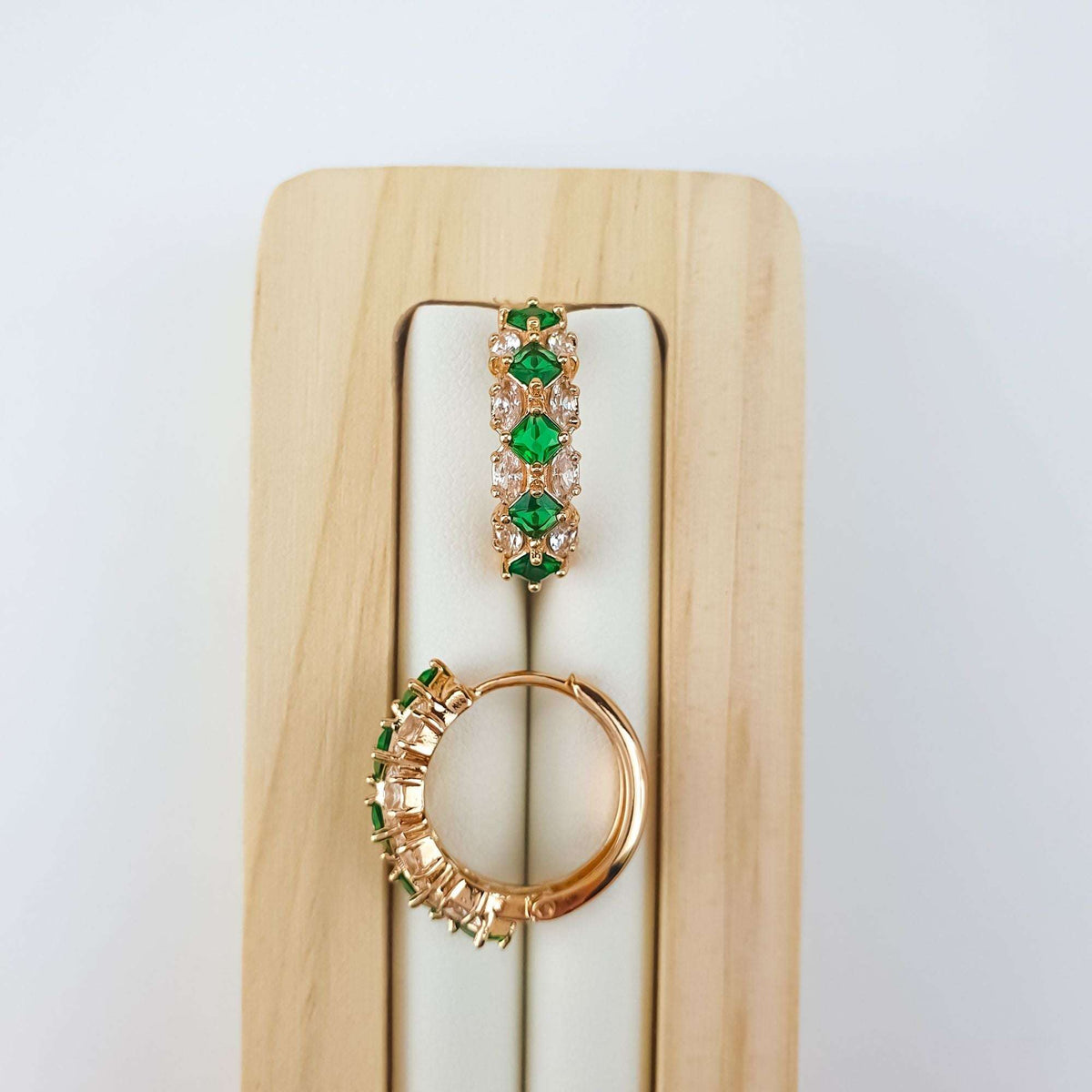 Green | Emerald green stones close up on a wooden stand, round hoop profile
