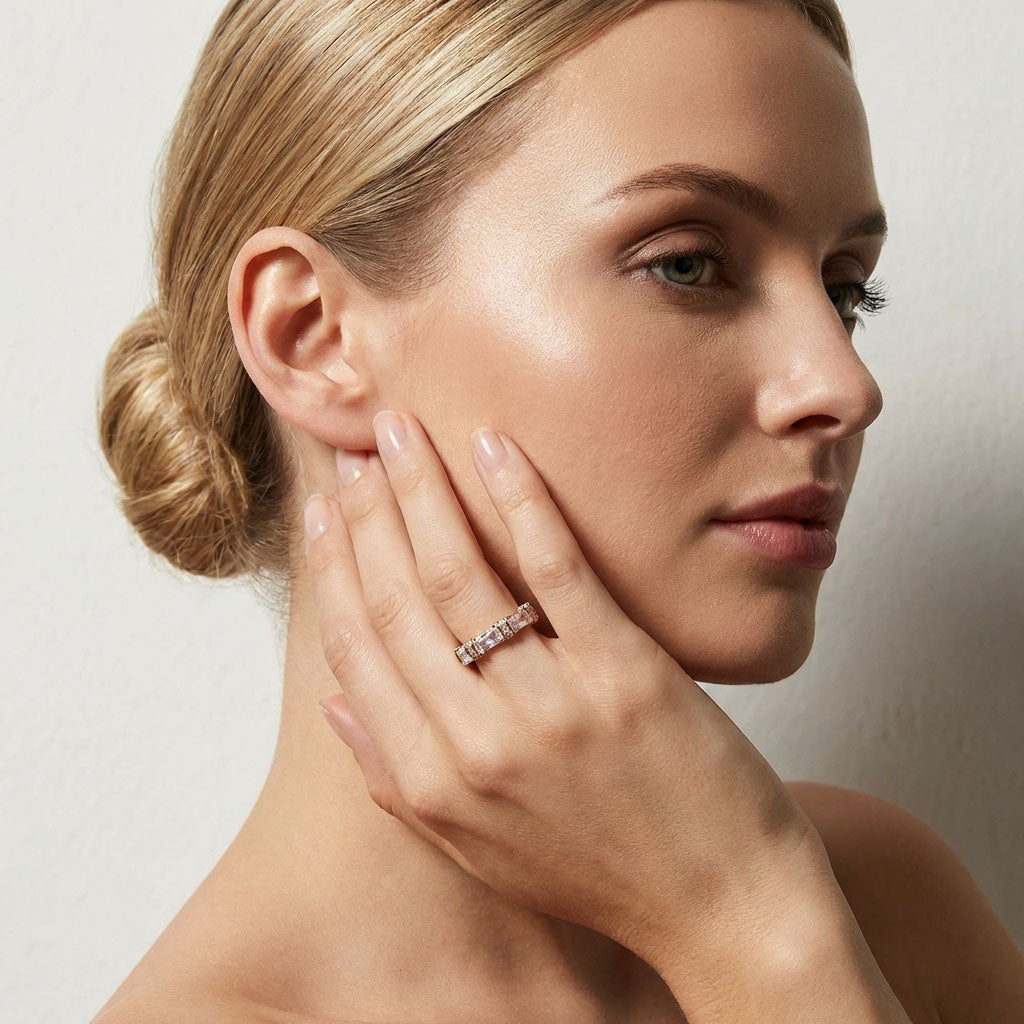 Blonde woman touching her cheek, wearing a gold-tone ring with rectangular stones