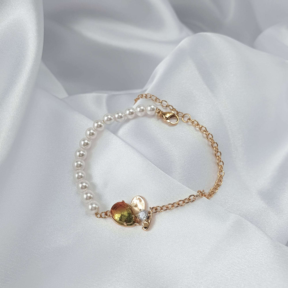Pearl bead bracelet on white silk showing the clasp, extender and heart stone