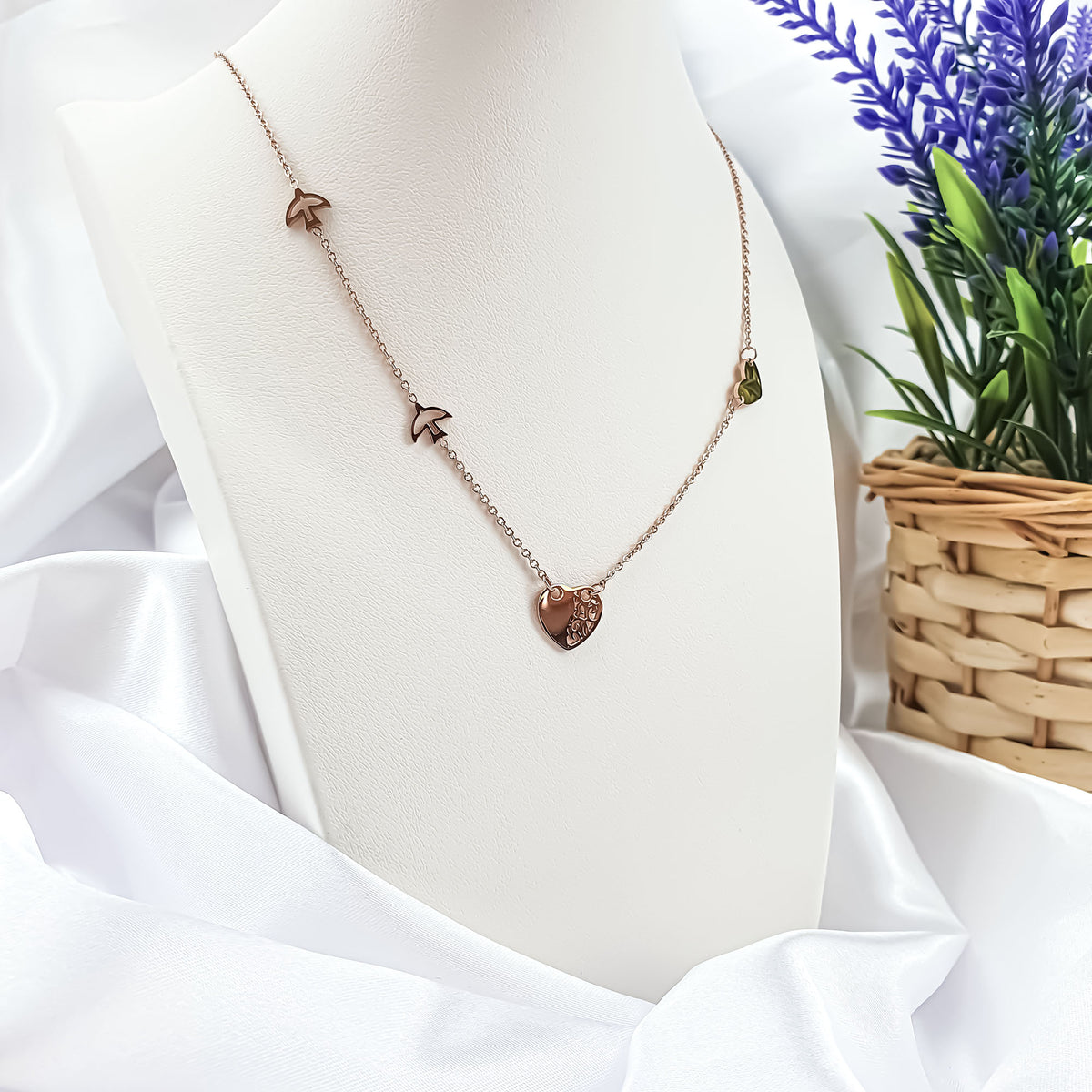 Heart and birds necklace on a white jewellery stand