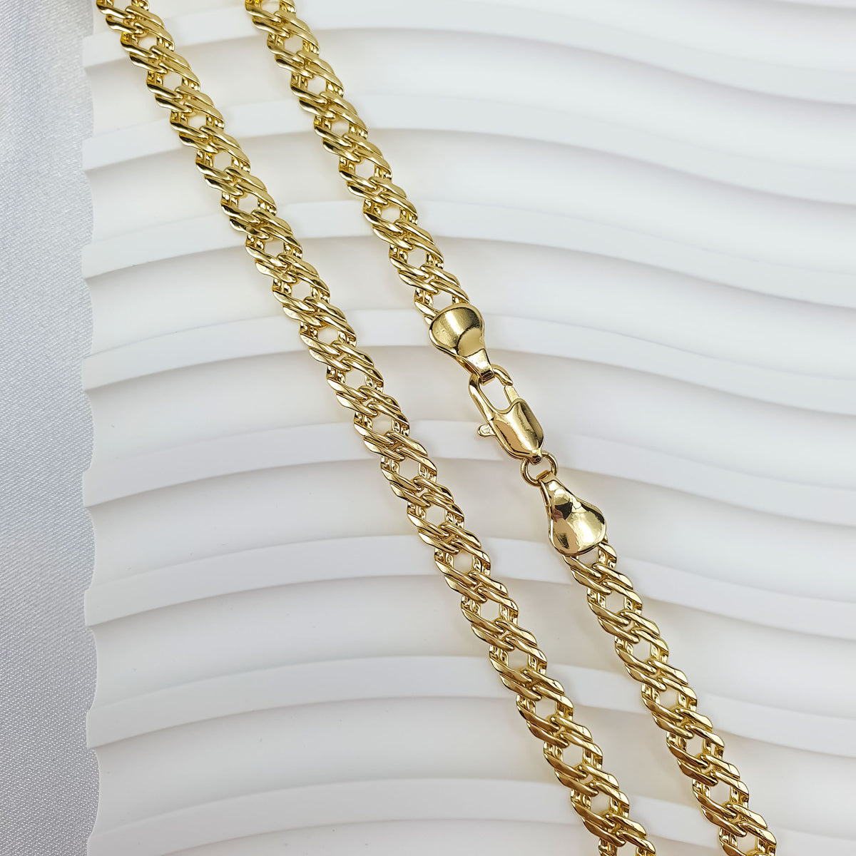 Chunky Rombo chain with a gold-tone finish and a secure lobster clasp