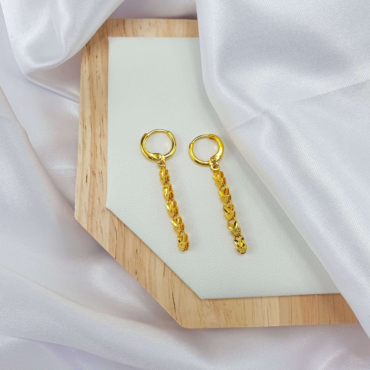 Heart chain earrings on a wooden stand, French hooks and gold links visible