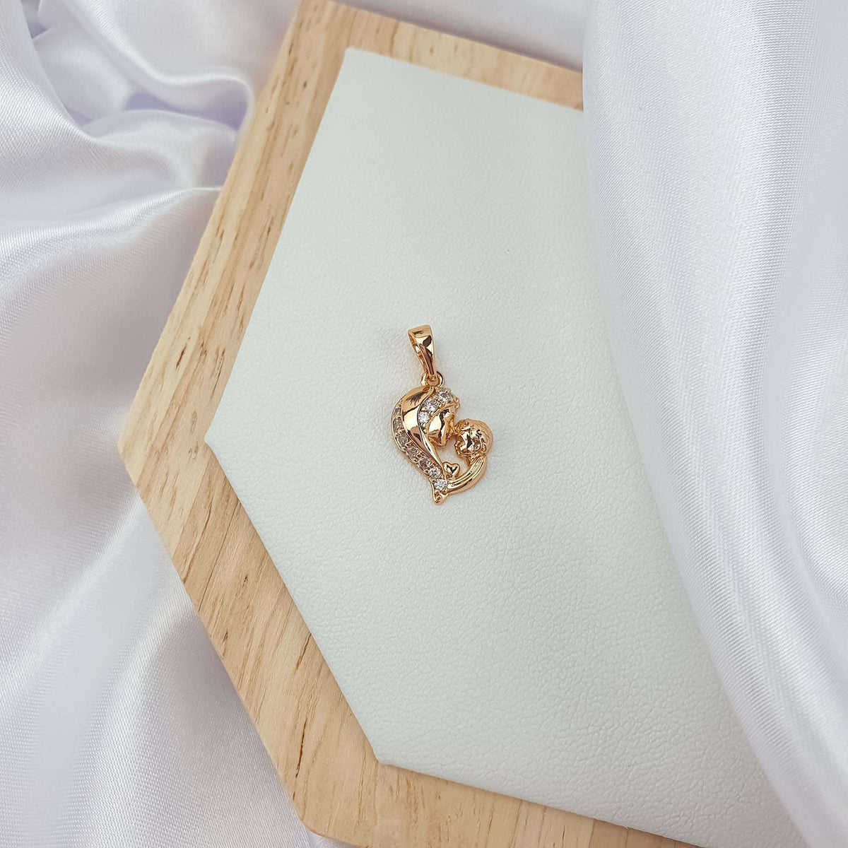 Gold | Small gold-plated mother and child pendant on a light leather tray