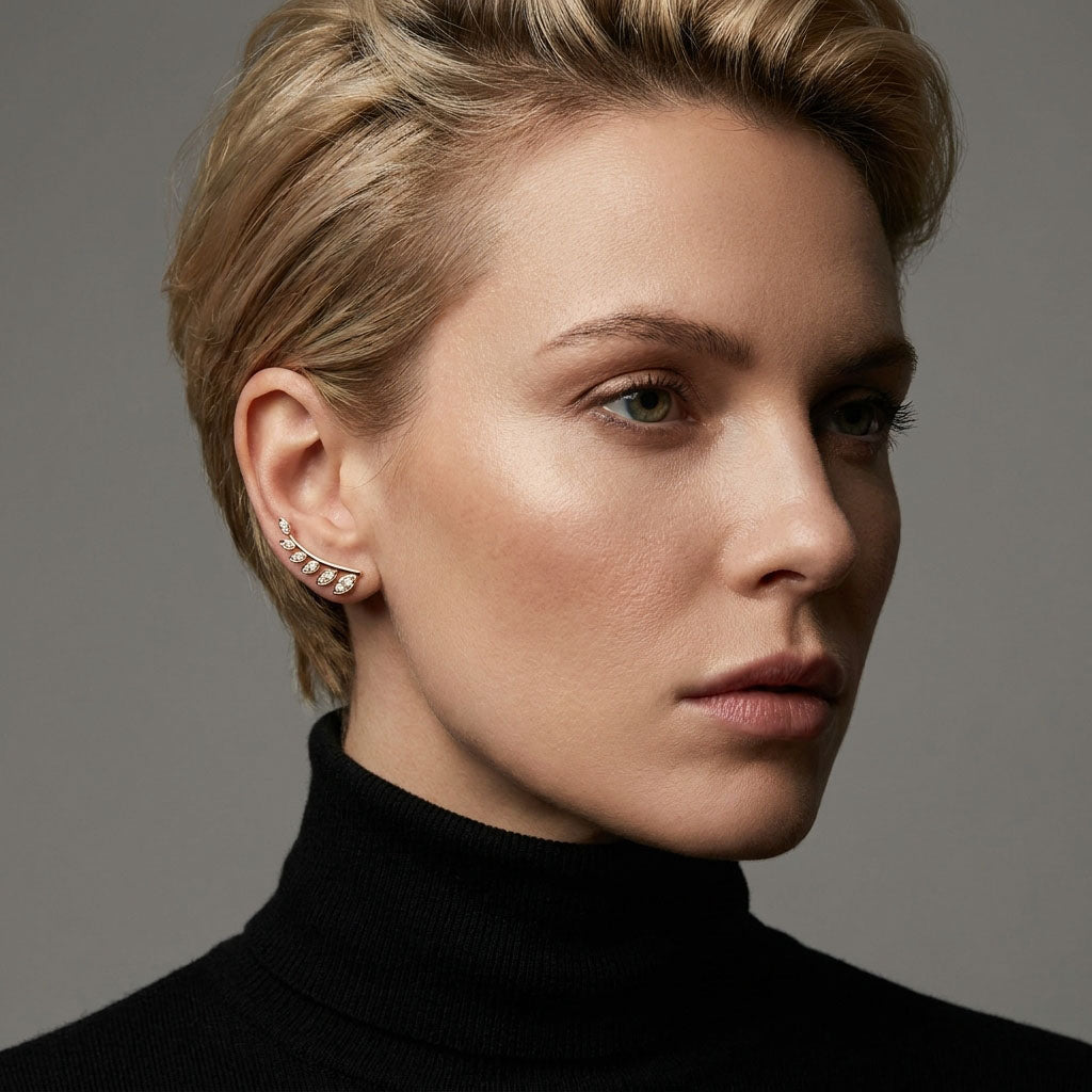 Model wearing a gold-plated leaf ear climber curving along the upper ear