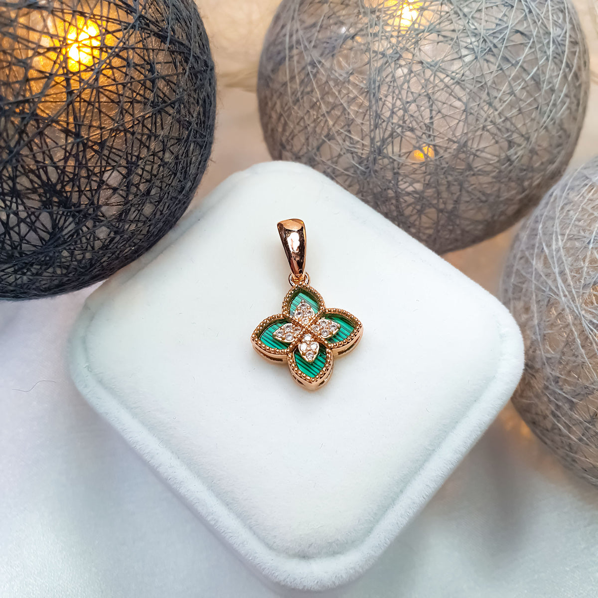Green clover pendant in a warm gold tone on a white velvet box