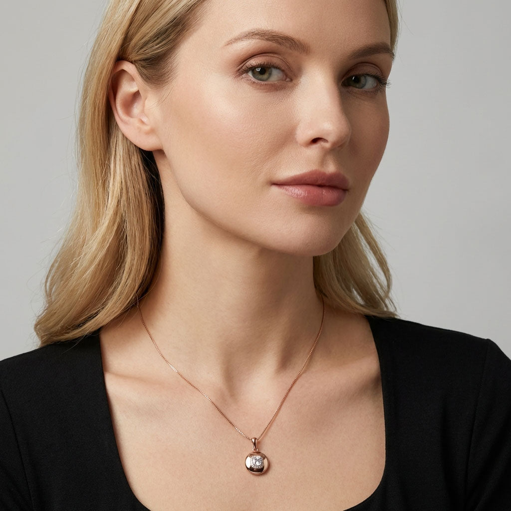 Woman in a black top wearing round gold-tone pendant on a chain