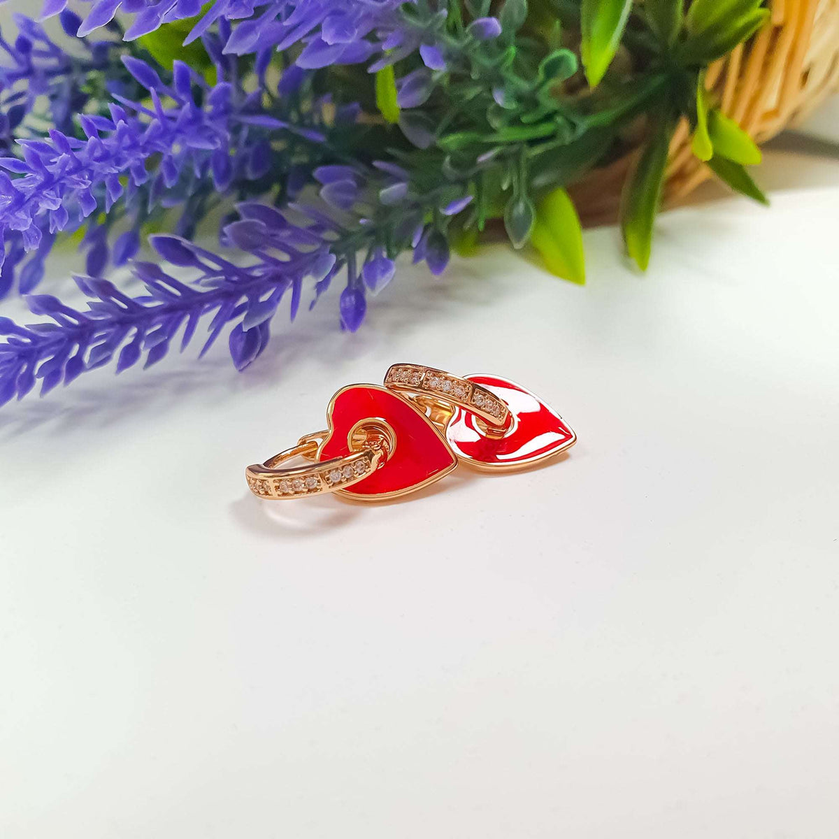 Side view of gold-plated cubic zirconia hoops with removable red enamel hearts