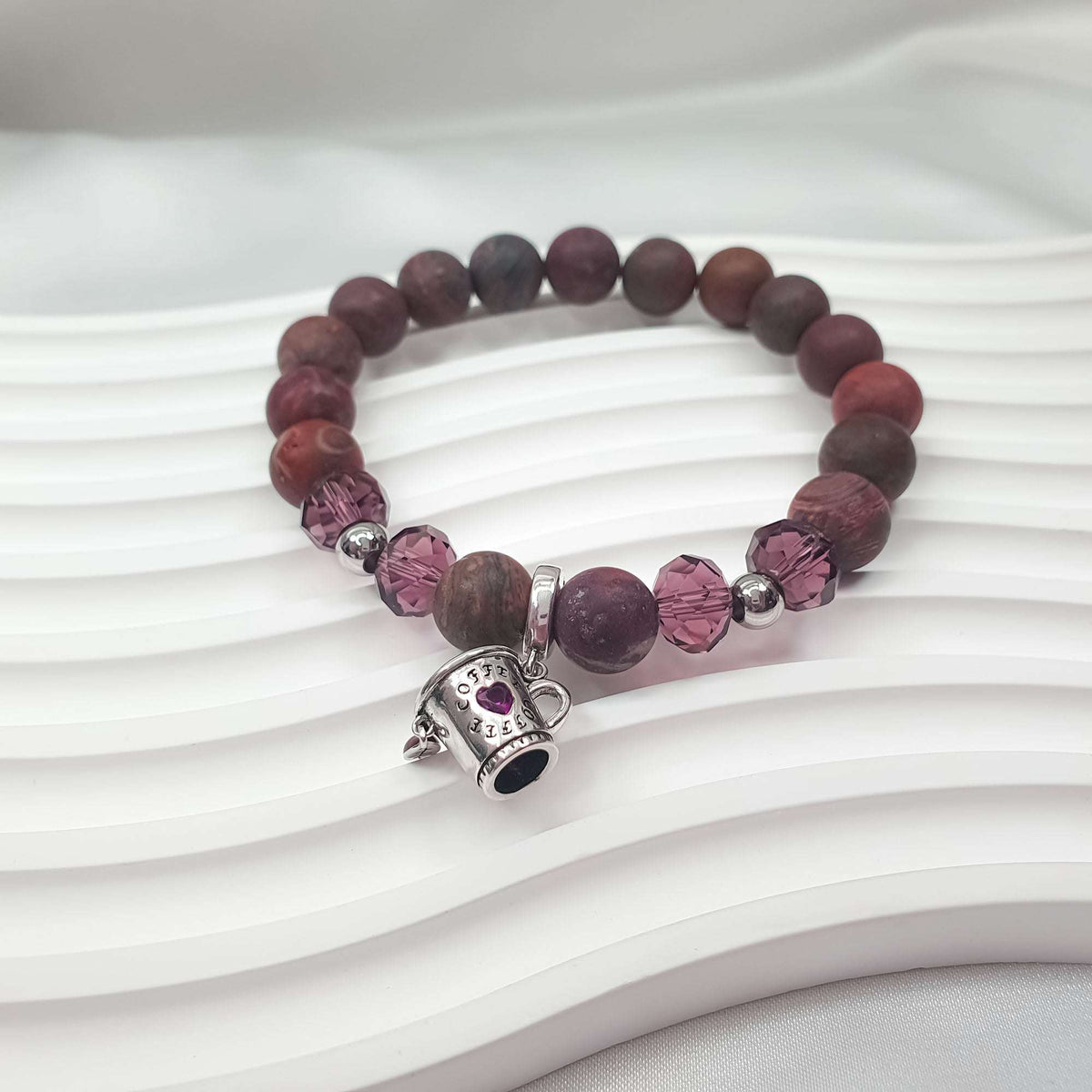 Side view close-up of the faceted violet crystals and coffee cup charm
