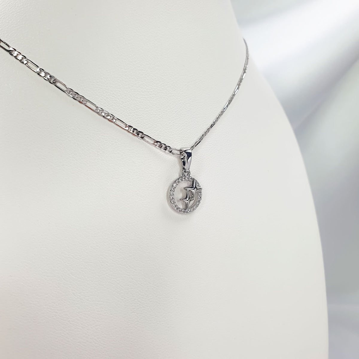 Close-up of star pendant with cubic zirconia on a fine silver-tone Figaro chain