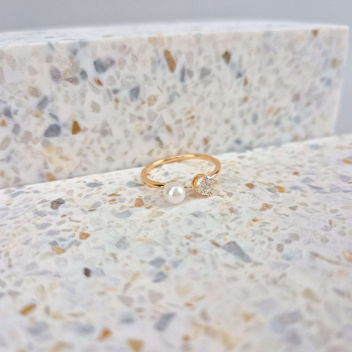 Side view of the pearl and cubic zirconia ring on speckled stone
