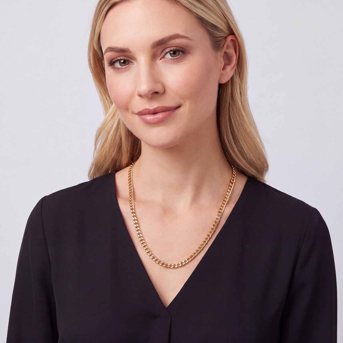 Blonde woman wearing a gold-plated curb chain with a linen shirt
