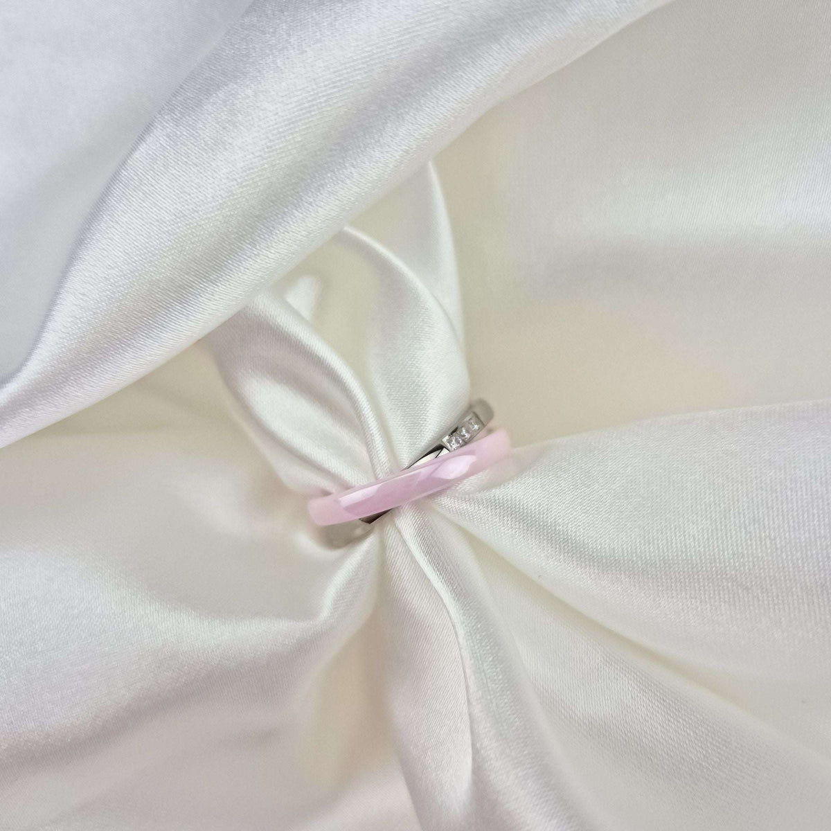 Close-up of the pink ceramic and platinum-tone ring on cream silk