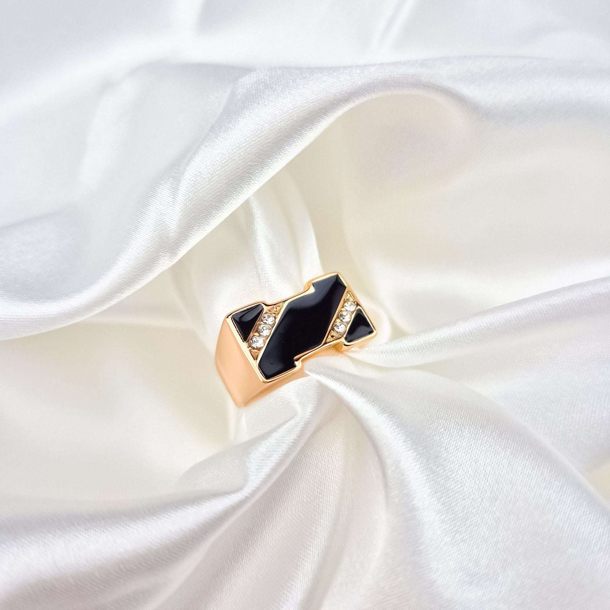 Gold-plated ring with a geometric black enamel pattern and cubic zirconia on silk