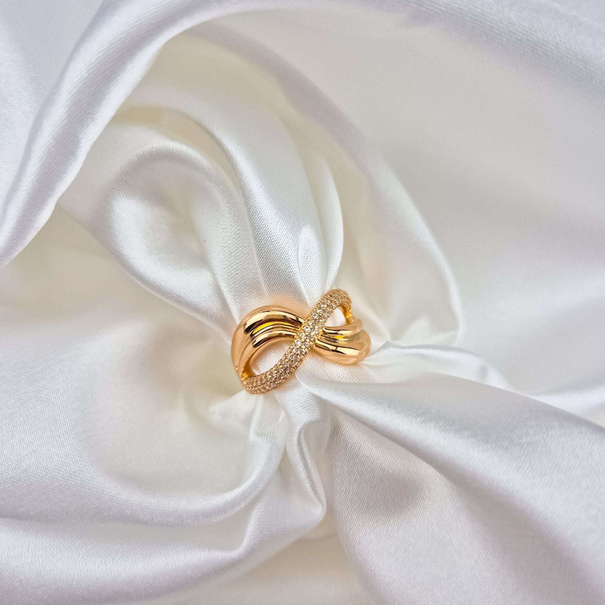 Infinity ring with cubic zirconia on folds of white silk