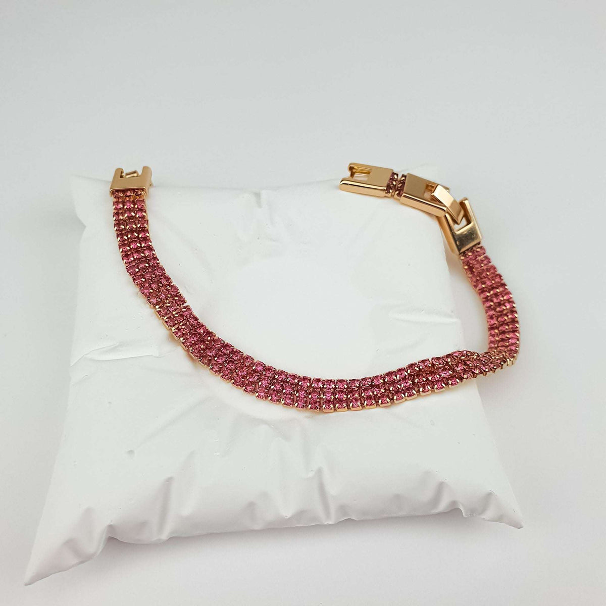 Gold-plated bracelet with three rows of pink stones and a secure box clasp