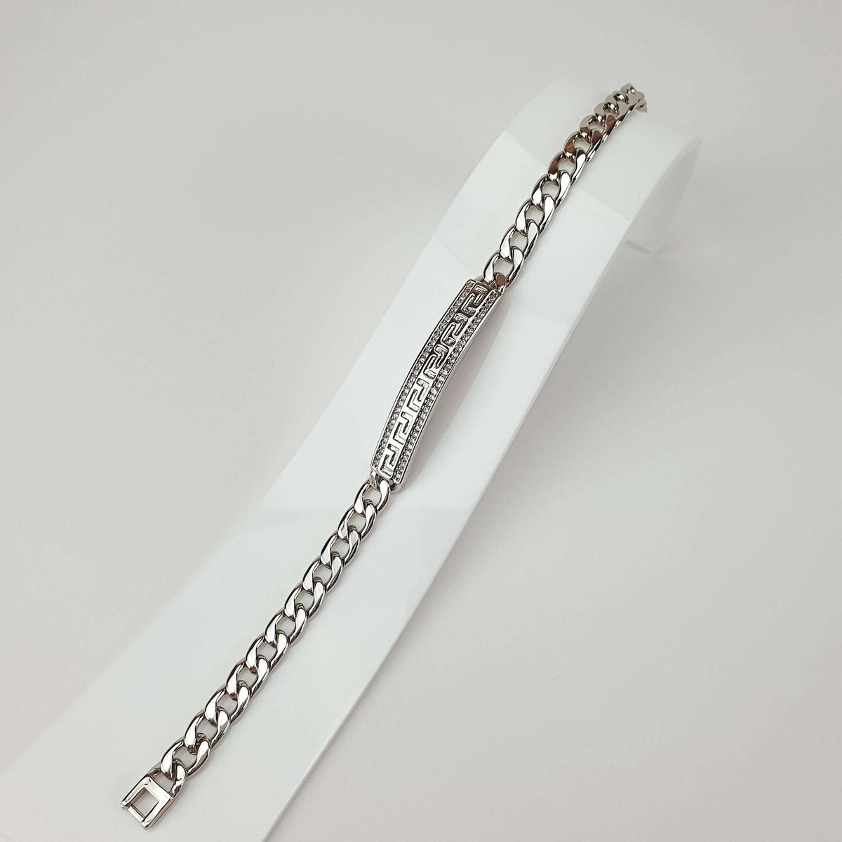 Full-length Greek key bracelet on a white stand, sparkling zirconia border
