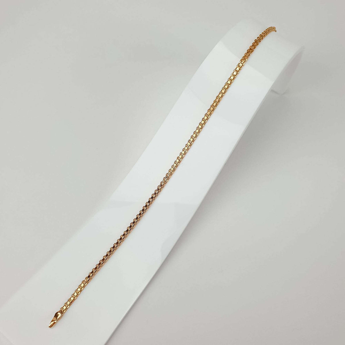 Gold | Bismarck bracelet in full length on a white stand, close-up of the gold-tone texture