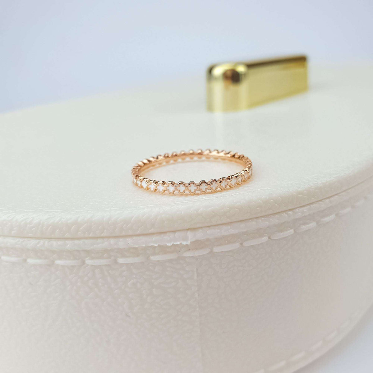 Side view of the flower ring on a cream jewellery box