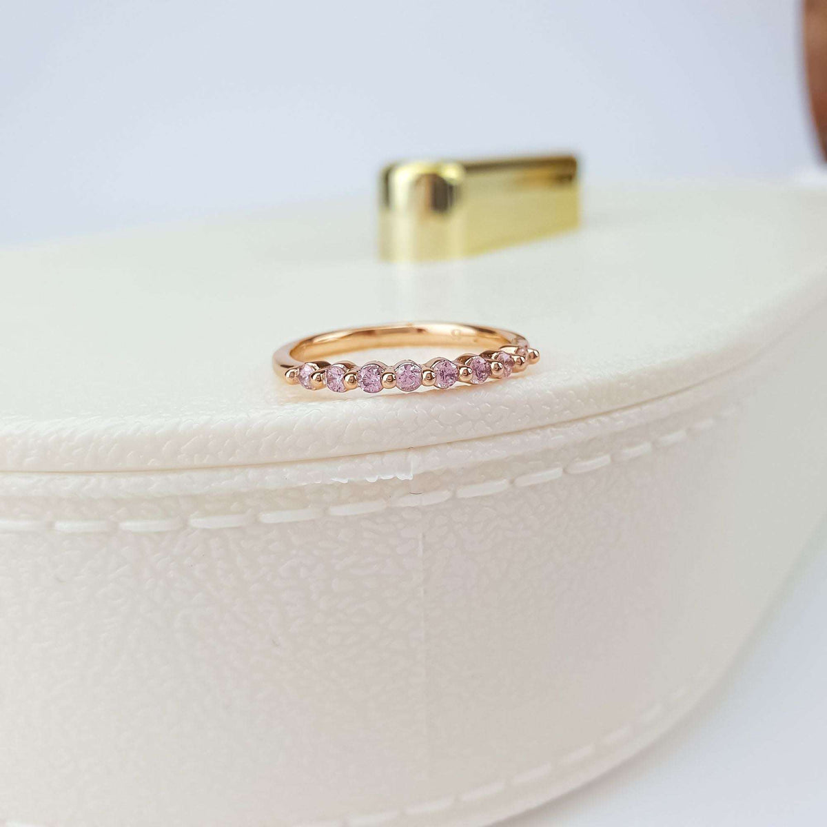 Gold-plated pink crystal ring on a pale leather gift box