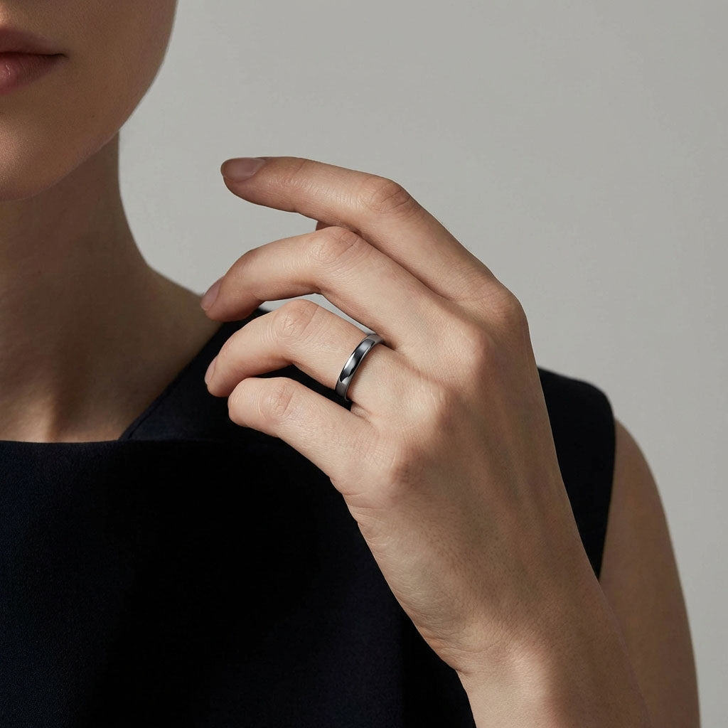 Hematite ring on a model's finger, a smooth shiny band for a minimalist look
