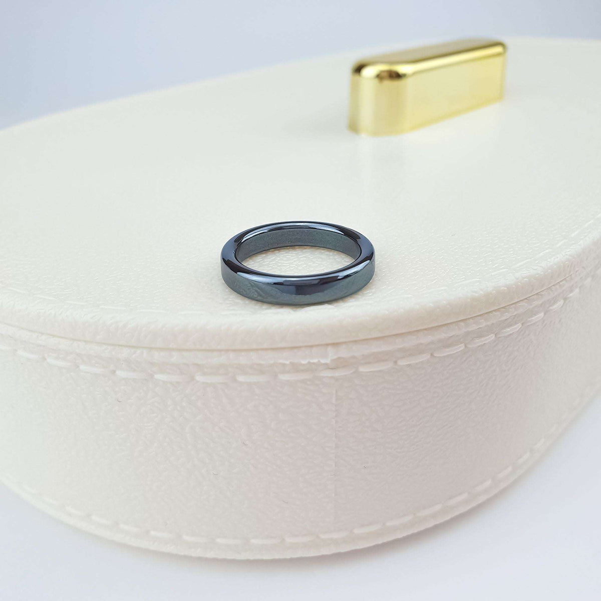 Shiny hematite ring on a cream jewellery box with a gold-tone clasp