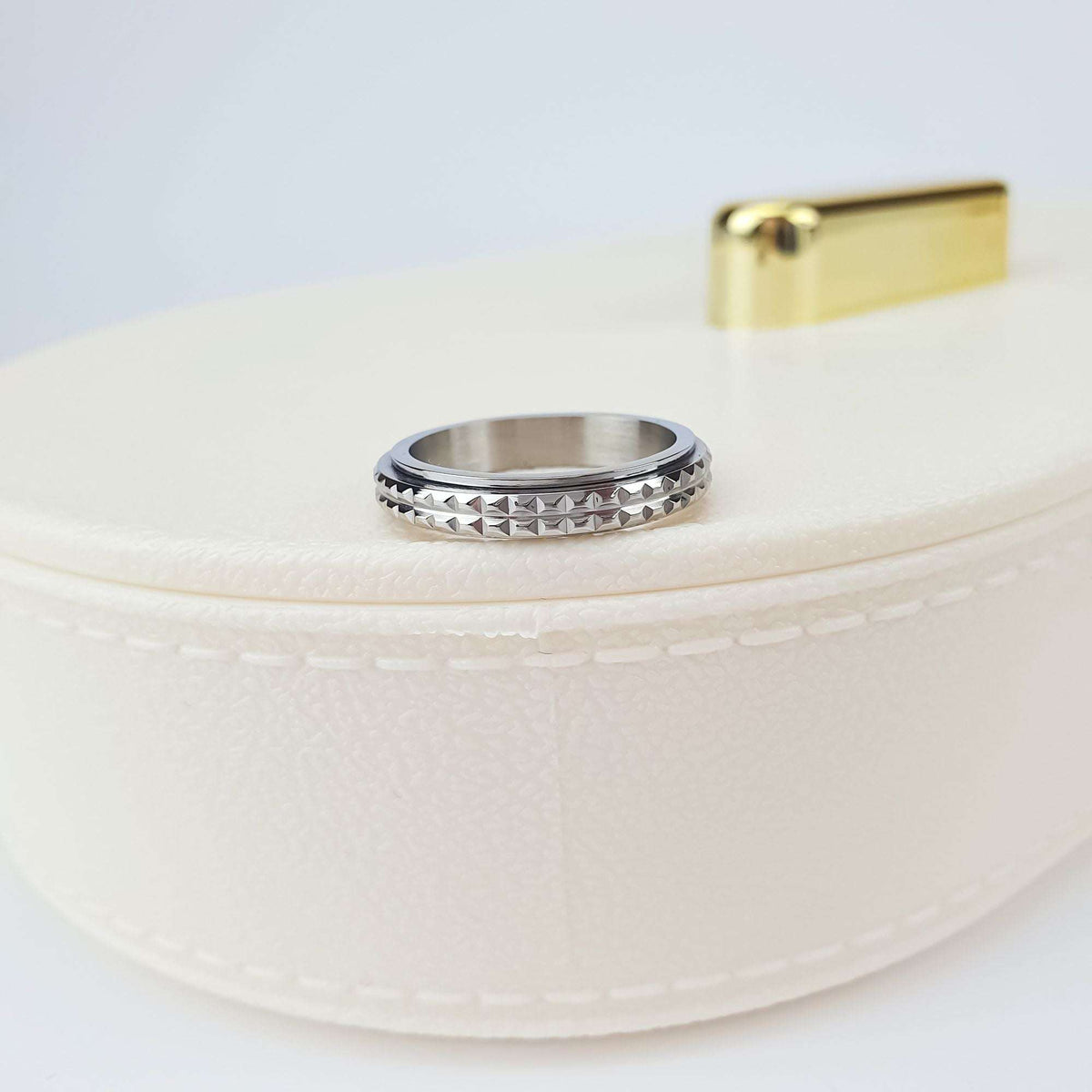 Close-up of the pyramid relief ring on a white jewellery box