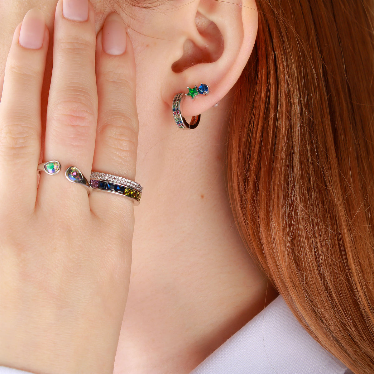 Model wearing earrings and the silver-tone ring with colourful crystals