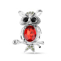 Silver-tone owl brooch with a large red stone and black eyes on a branch