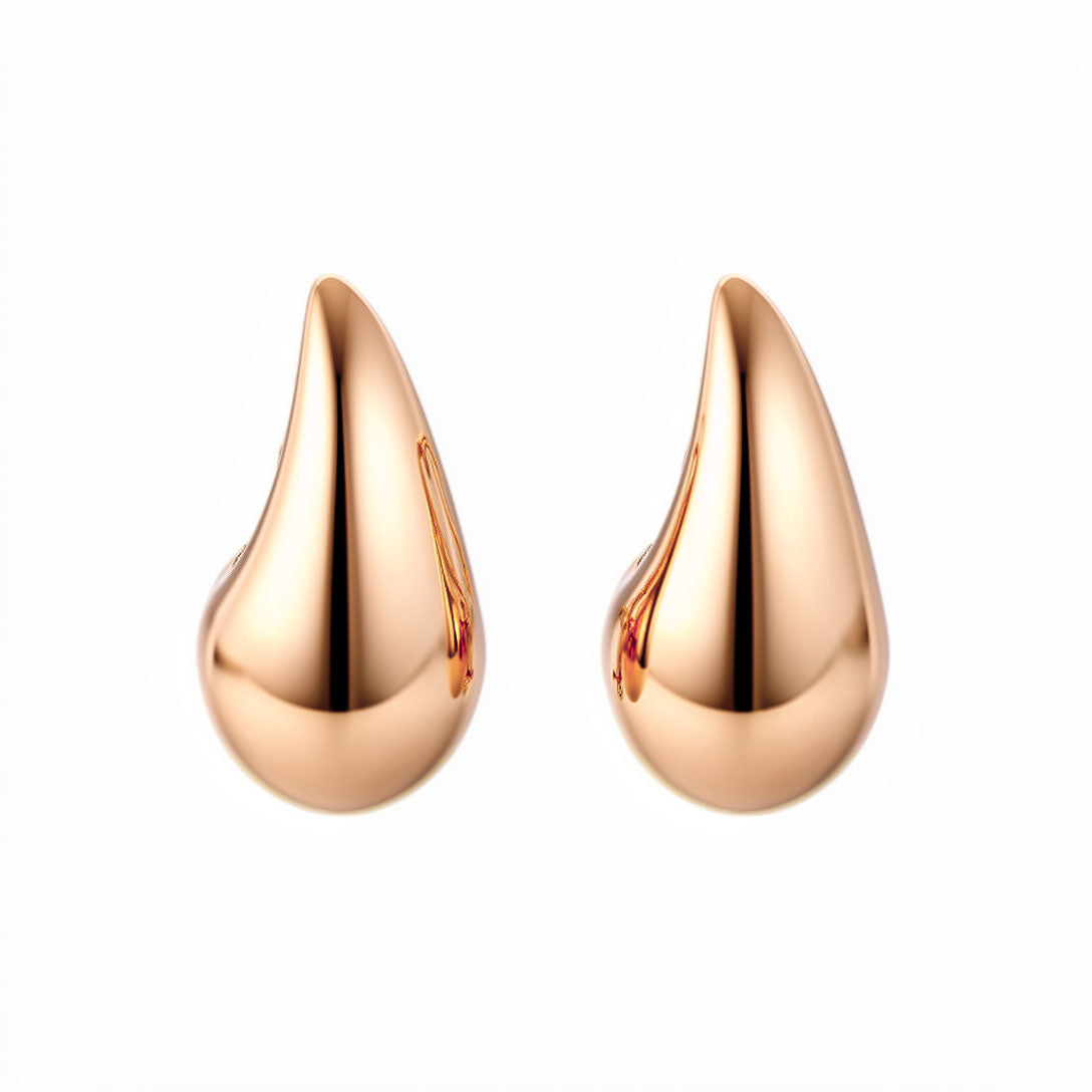 Chunky teardrop stud earrings with a smooth mirror finish in gold tone