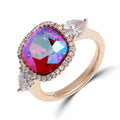 Gold-tone ring with a large multicoloured crystal, stone halo and teardrop side stones