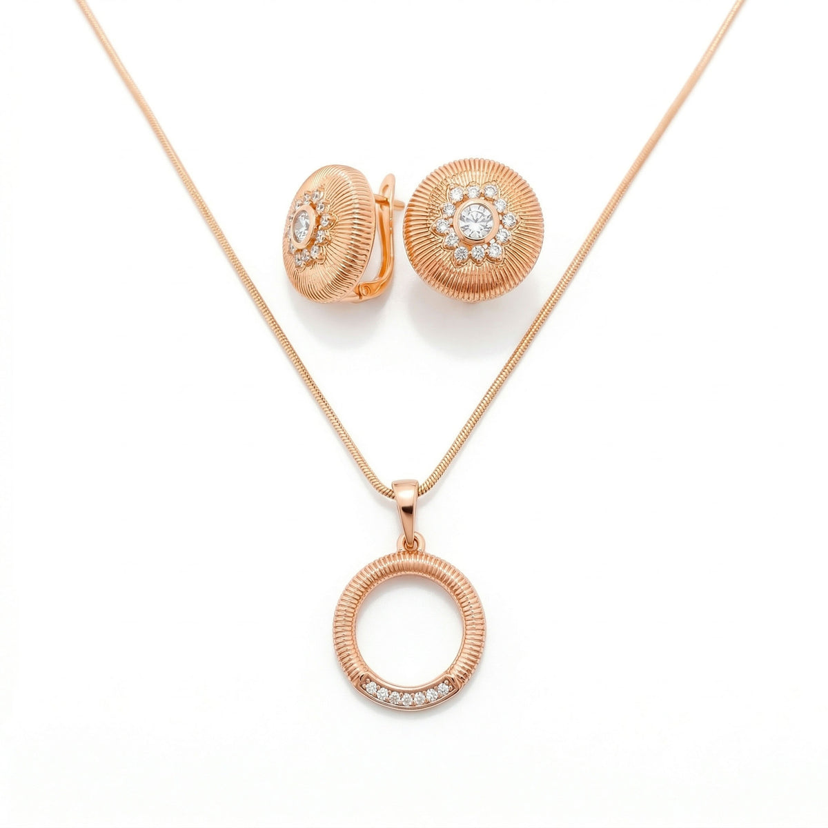 Ribbed gold-plated round earrings and an open ring pendant on a snake chain