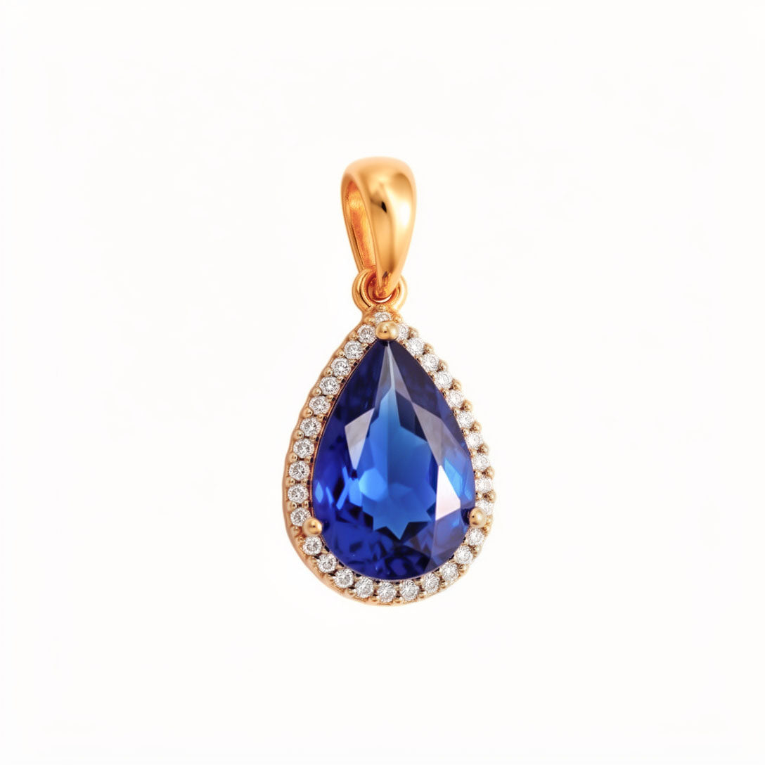 Gold-plated teardrop pendant with a deep blue cubic zirconia in a white stone halo
