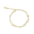 Gold-tone double bracelet with polished square and oval elements on white